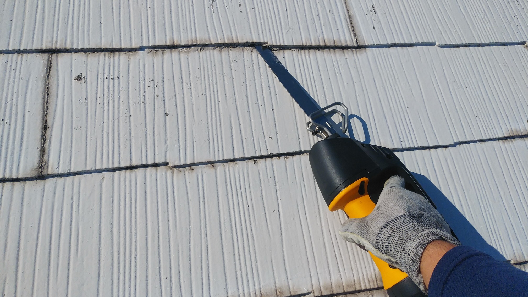 カラーベスト屋根のカバー工法の前の頑固な塗膜の縁切り作業